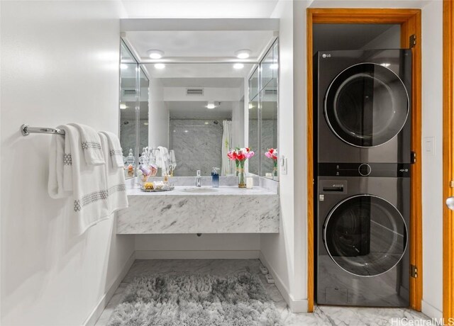 bathroom with walk in shower, vanity, and stacked washer and dryer