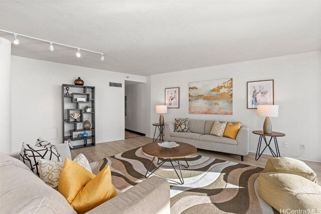 living room with track lighting and light hardwood / wood-style floors