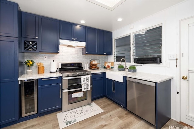 kitchen featuring light hardwood / wood-style floors, wine cooler, blue cabinetry, appliances with stainless steel finishes, and sink