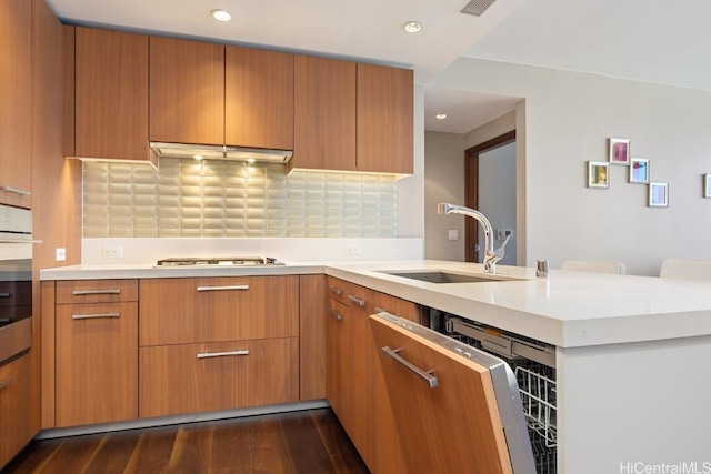 kitchen with tasteful backsplash, sink, gas cooktop, and dark hardwood / wood-style flooring