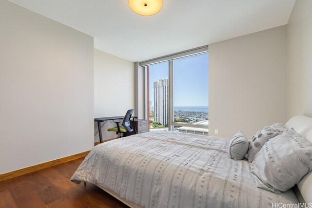 bedroom with dark wood-type flooring and a wall of windows