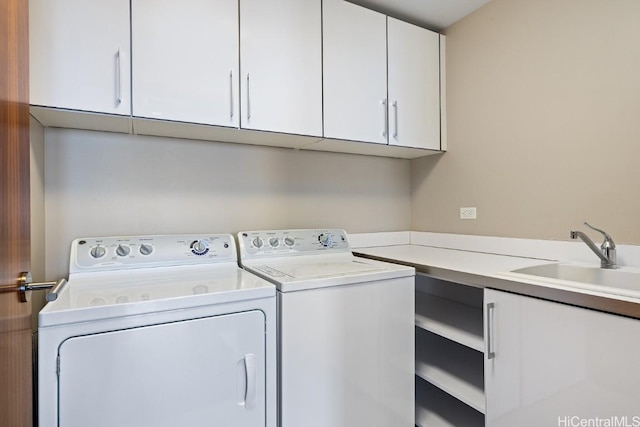 washroom with sink, cabinets, and washing machine and clothes dryer