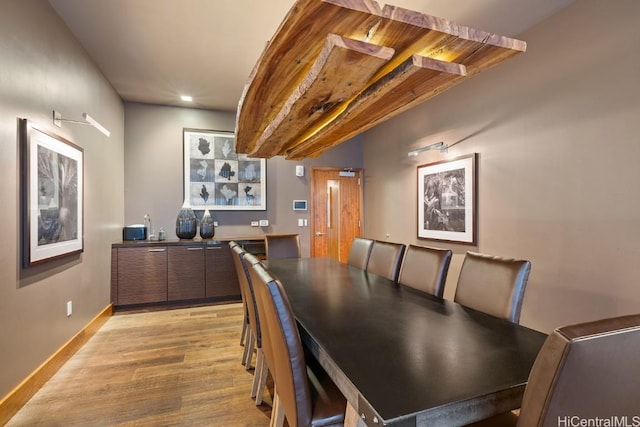 dining space featuring bar and light hardwood / wood-style floors