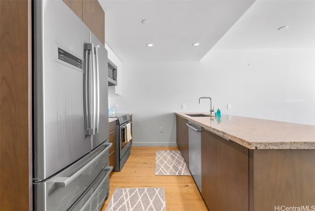 kitchen featuring sink, light wood-type flooring, and appliances with stainless steel finishes