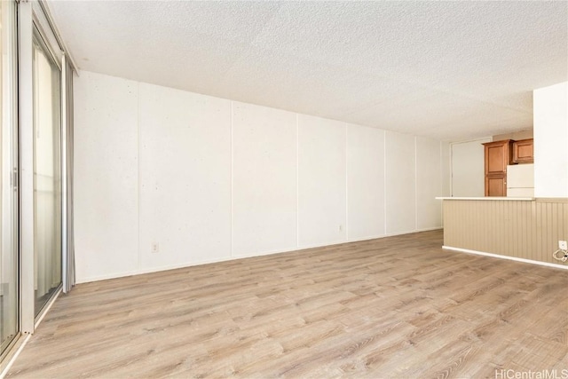 unfurnished room featuring a textured ceiling and light hardwood / wood-style floors