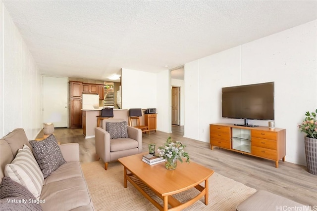 living room featuring light hardwood / wood-style floors and a textured ceiling