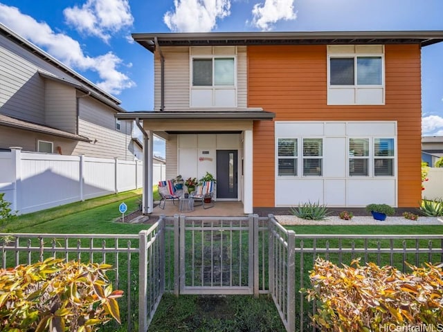 view of front facade featuring covered porch, a front lawn, and a fenced front yard