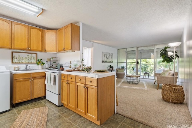 kitchen with white electric range oven, sink, kitchen peninsula, and a textured ceiling