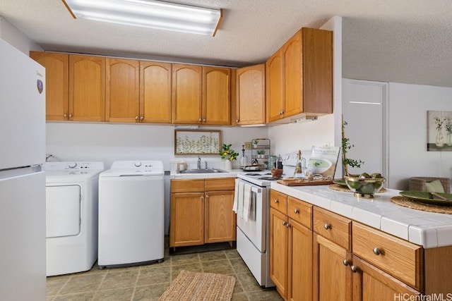 laundry room featuring independent washer and dryer, a textured ceiling, and sink