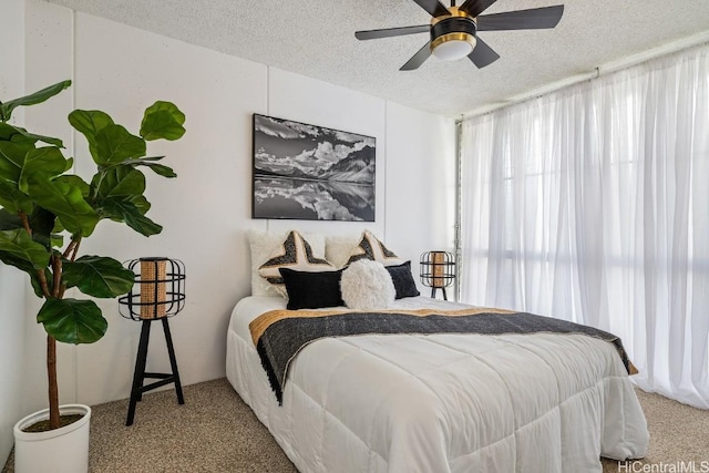 bedroom featuring a textured ceiling, carpet floors, and ceiling fan