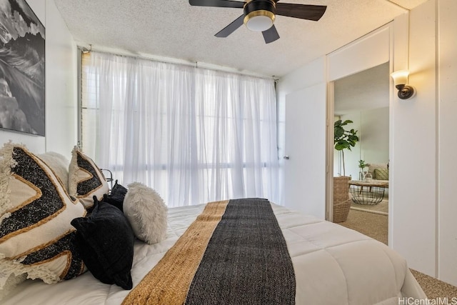 bedroom with ceiling fan and a textured ceiling