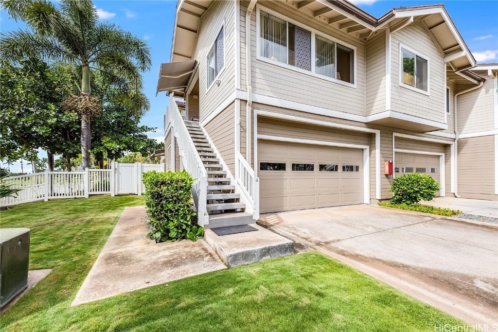 multi unit property with a garage and a front lawn