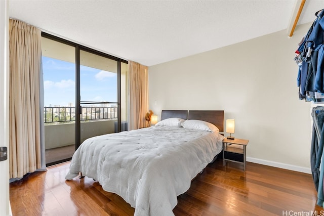 bedroom with access to outside and wood-type flooring