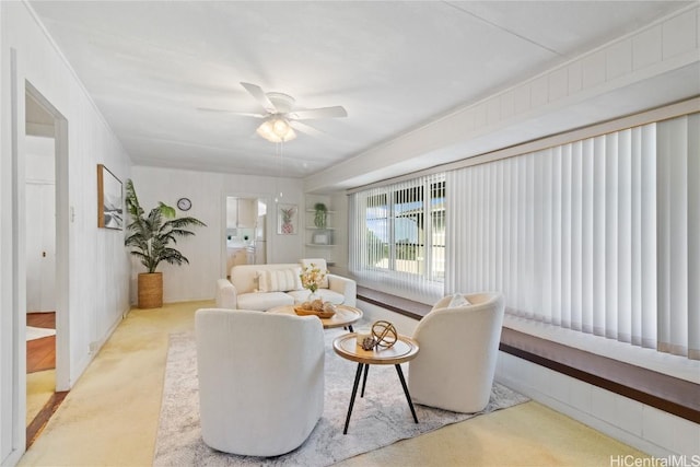 carpeted living room with ceiling fan