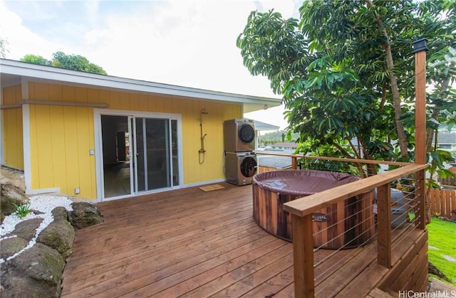 wooden deck featuring stacked washing maching and dryer