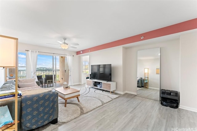 living room featuring ceiling fan and hardwood / wood-style floors