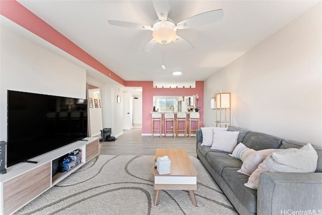 living room featuring light wood-type flooring and ceiling fan