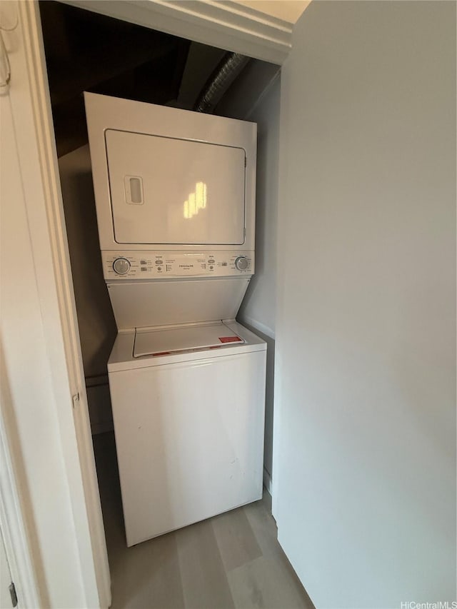 washroom featuring stacked washer and dryer and laundry area