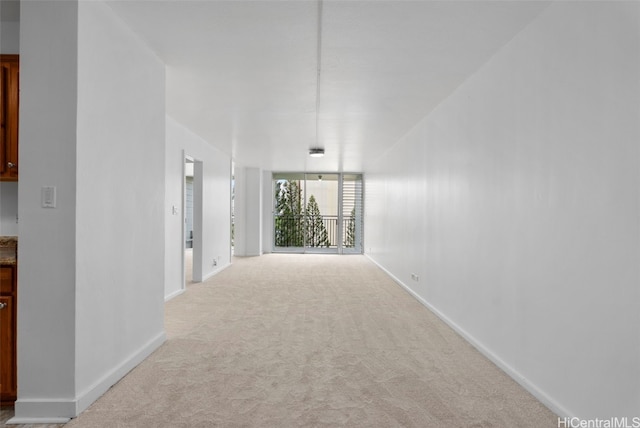 hall with baseboards and carpet