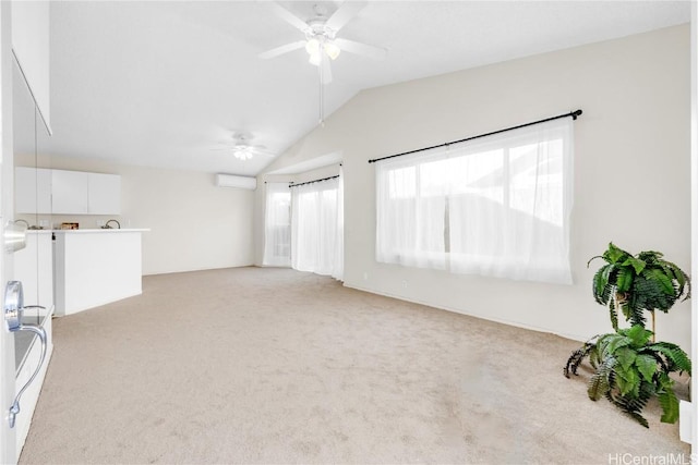 carpeted empty room with a wall mounted air conditioner, ceiling fan, and lofted ceiling