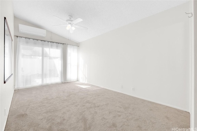 spare room featuring lofted ceiling, light carpet, ceiling fan, a textured ceiling, and a wall mounted AC