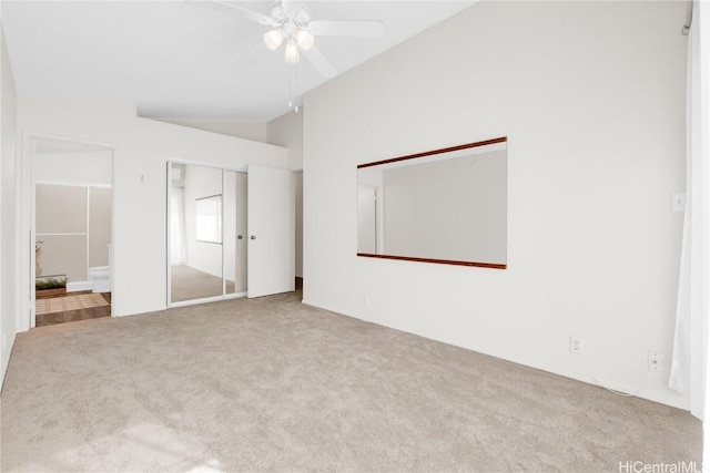 unfurnished bedroom featuring light carpet, vaulted ceiling, and ceiling fan