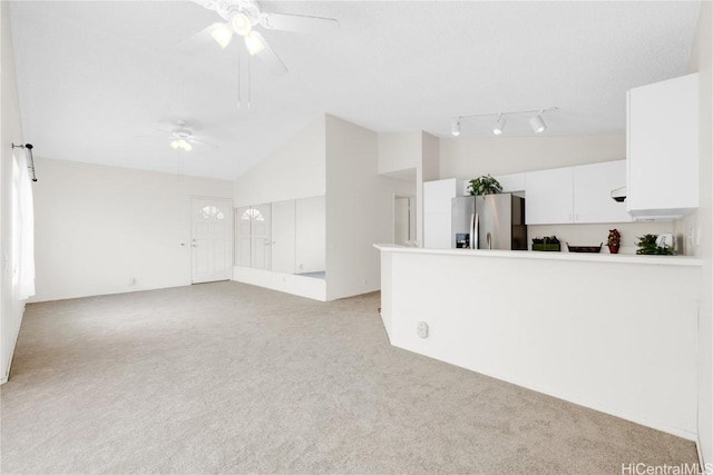 spare room with ceiling fan, light colored carpet, and high vaulted ceiling