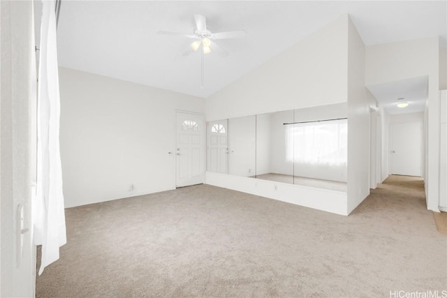 unfurnished room with ceiling fan, high vaulted ceiling, and light colored carpet