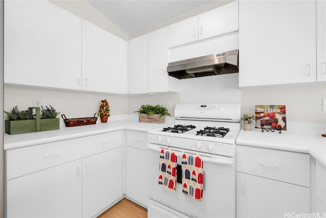 kitchen with white range with gas stovetop, a textured ceiling, white cabinets, and exhaust hood