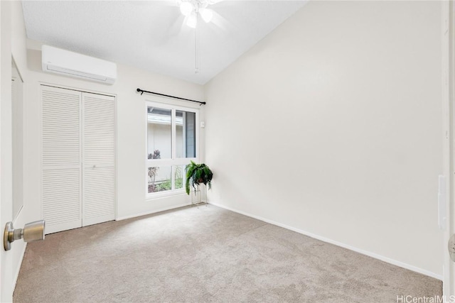 unfurnished bedroom featuring an AC wall unit, ceiling fan, a closet, and light colored carpet