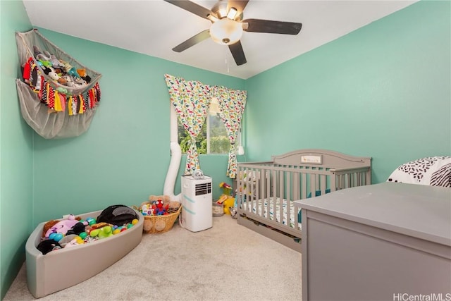 bedroom with carpet flooring, ceiling fan, and a nursery area