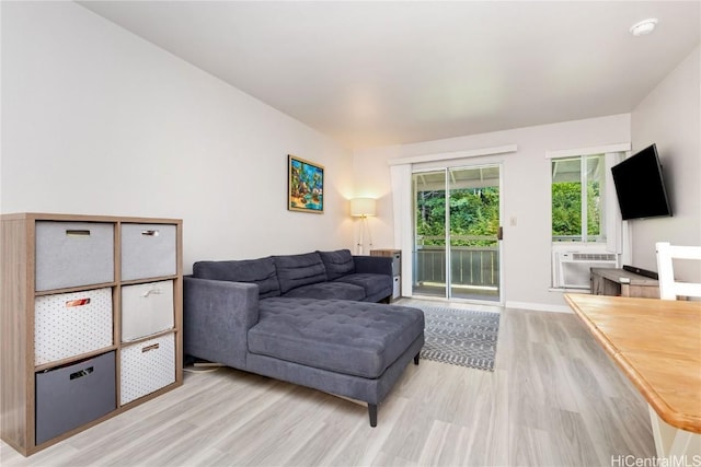 living room with cooling unit and light hardwood / wood-style flooring