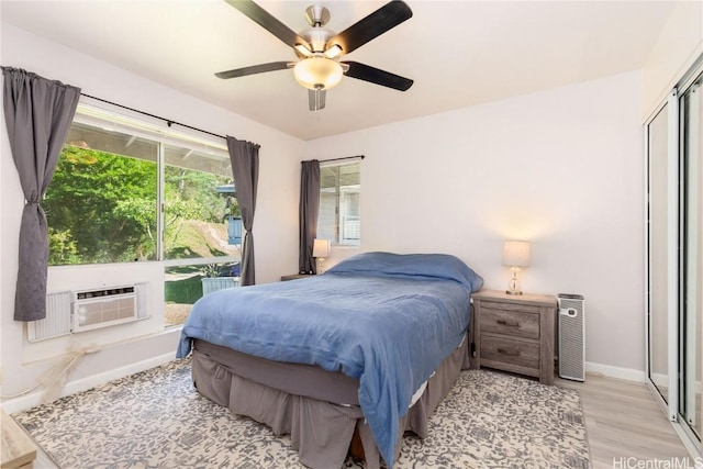 bedroom with ceiling fan, a closet, cooling unit, and light hardwood / wood-style floors