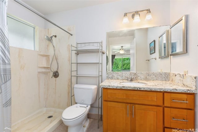 bathroom with ceiling fan, toilet, vanity, and walk in shower