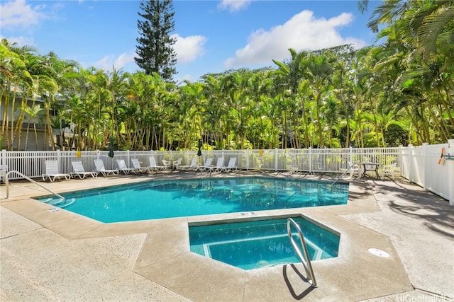 view of swimming pool with a patio and a hot tub