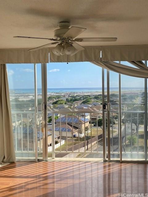 entryway with ceiling fan and a water view