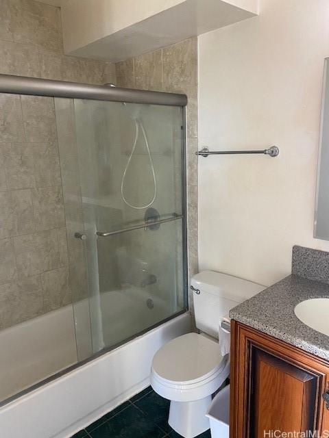 full bathroom featuring tile patterned flooring, shower / bath combination with glass door, vanity, and toilet