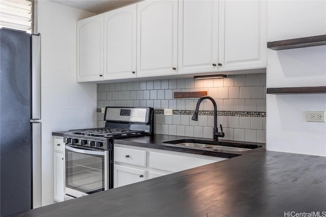 kitchen with sink, decorative backsplash, white cabinets, and appliances with stainless steel finishes