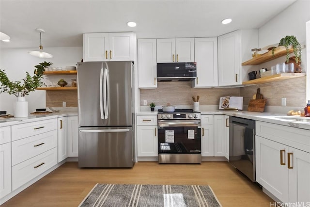 kitchen featuring pendant lighting, backsplash, black appliances, white cabinets, and light hardwood / wood-style floors