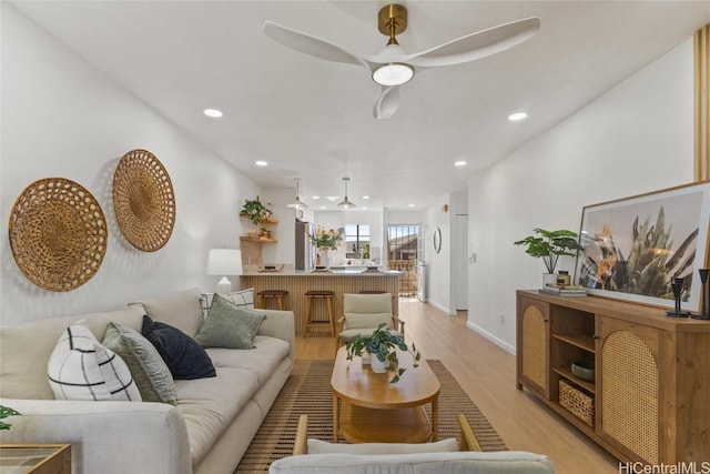 living room featuring ceiling fan and light wood-type flooring