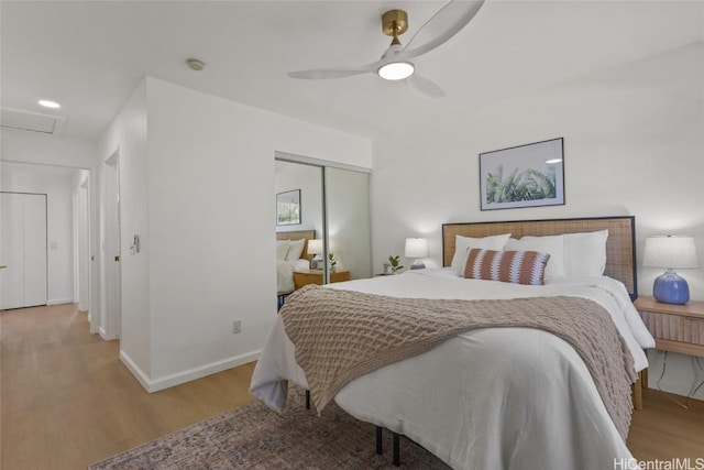 bedroom with ceiling fan, light hardwood / wood-style floors, and a closet