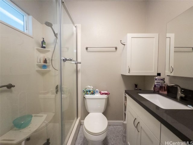 bathroom with tile patterned floors, a shower with door, vanity, and toilet