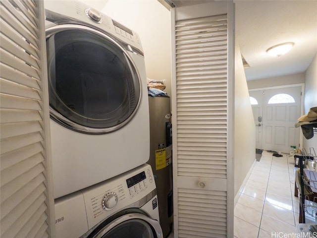 washroom with water heater, light tile patterned floors, and stacked washer and clothes dryer