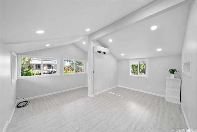 interior space featuring light hardwood / wood-style flooring, a wall unit AC, and lofted ceiling