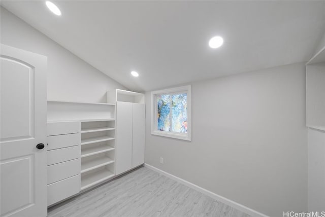 walk in closet with light hardwood / wood-style flooring and lofted ceiling