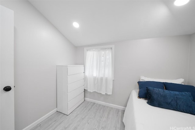 bedroom featuring light hardwood / wood-style floors and vaulted ceiling