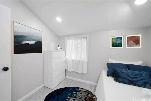 bedroom featuring light hardwood / wood-style floors and lofted ceiling