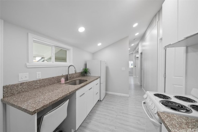 kitchen featuring white cabinetry, sink, dark stone counters, and white appliances