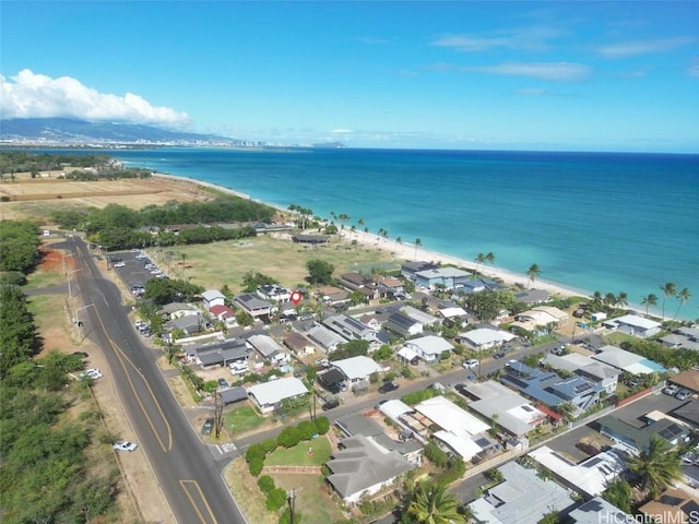 birds eye view of property with a water view and a beach view