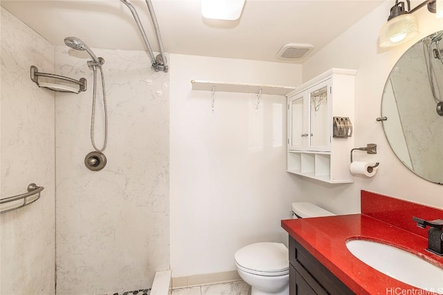 bathroom featuring vanity, toilet, and tiled shower